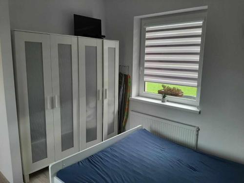 1 dormitorio con cama y ventana en Apartament Rychwałd en Rychwałd