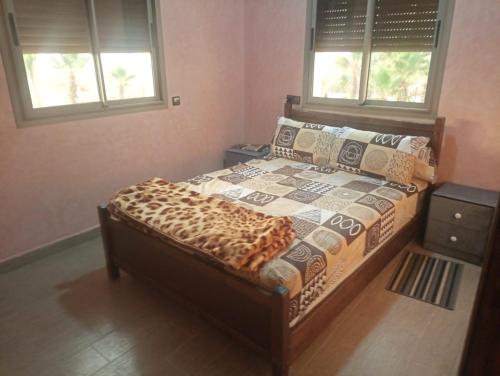 een slaapkamer met een bed in een kamer met 2 ramen bij Disney land villa in Gourizim