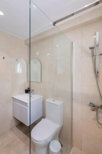 a bathroom with a toilet and a glass shower at Epicurian Residence in Nicosia