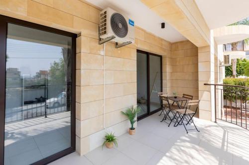 a patio with sliding glass doors and a table on a balcony at Epicurian Residence in Nicosia