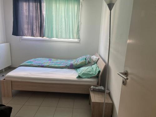 un petit lit dans une chambre avec une fenêtre dans l'établissement chez Catherine tres beau logement tout équipé et proche des transports, à Marseille