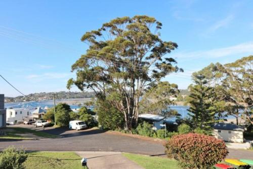 arial view of a house with a lake and trees at Osborne House - 4 Bedroom in Merimbula