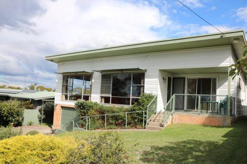 a small white house with a porch and a porch at Osborne House - 4 Bedroom in Merimbula