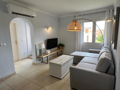 Una sala de estar con un sofá y un televisor. en Oliva Nova flat in front of MET, en Oliva