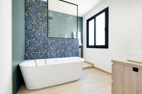 a bathroom with a white tub and a mirror at Maison de charme Bordeaux Bègles in Bègles