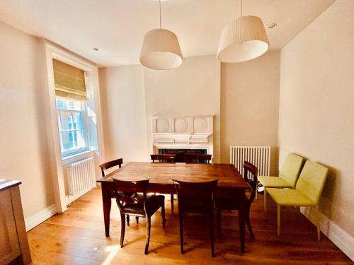 - une salle à manger avec une table et des chaises en bois dans l'établissement Charming central home by iconic landmarks nr, à Londres