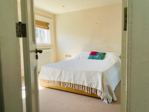 - une chambre avec un lit doté de draps blancs et une fenêtre dans l'établissement Charming central home by iconic landmarks nr, à Londres