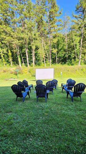 a group of chairs sitting in the grass with a white screen at Blue Sky Inn- Complimentary Happy Hour Th-Sun, Veteran owned, Full Breakfast, Best green space, 1 mile from Blue Ridge, Fire Pit in Blue Ridge