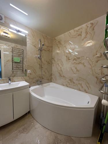 y baño con bañera blanca y lavamanos. en Апартаменти Білогірська НОВА, en Ternopilʼ