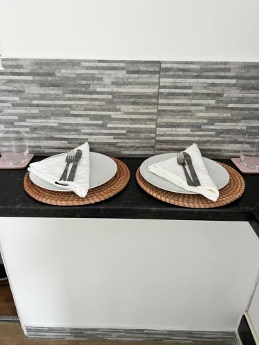 two plates and napkins on top of a table at Brand new cosy studio apartment in West Dulwich