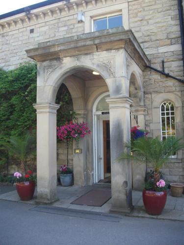 a stone building with potted plants in front of it at Hundith Hill Hotel in Cockermouth