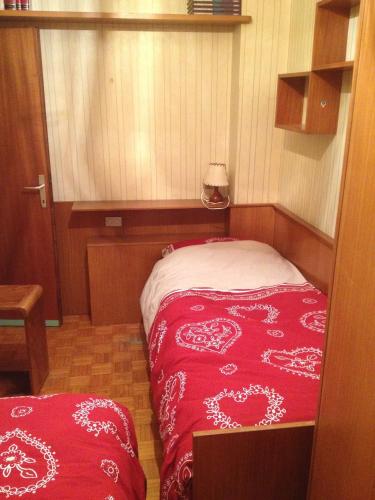 a small bedroom with a bed with a red blanket at Villa Montana in Moena