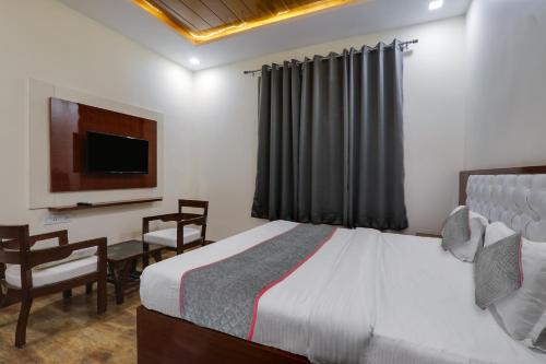 a bedroom with a bed and a desk and a television at Townhouse Hotel Trijal Inn in Lucknow