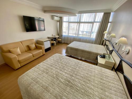 pokój hotelowy z 2 łóżkami i kanapą w obiekcie Hotel Maerkli w mieście Santo Ângelo