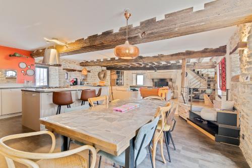 une cuisine et une salle à manger avec une table et des chaises dans l'établissement Manoir du Pont Gris Saint-Malo, à Saint-Malo