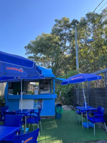 a group of blue tables and blue umbrellas at Frontemare Residence in Fiumefreddo di Sicilia