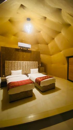 a bedroom with two beds and a light on the ceiling at Syndebad desert camp in Wadi Rum