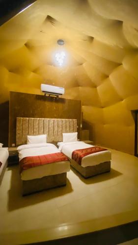 a bedroom with two beds and a ceiling at Syndebad desert camp in Wadi Rum