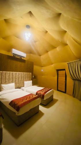 two beds in a room with a yellow ceiling at Syndebad desert camp in Wadi Rum