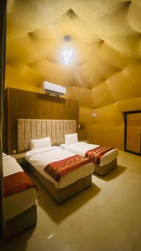 two beds in a room with a ceiling at Syndebad desert camp in Wadi Rum