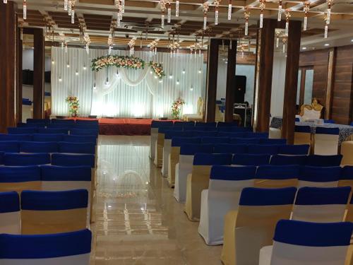 a hall with blue and white chairs and a stage at PRIME LAND in Varanasi