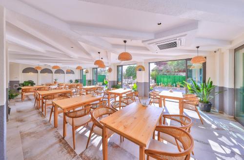 an empty restaurant with wooden tables and chairs at Kas Athena Hotel in Kas