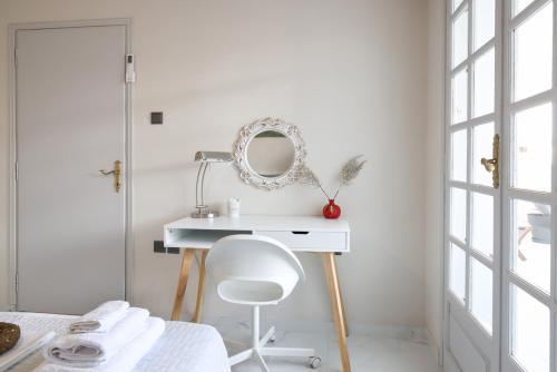 Habitación con escritorio blanco con espejo y silla. en The Terrace Kiss, en Atenas
