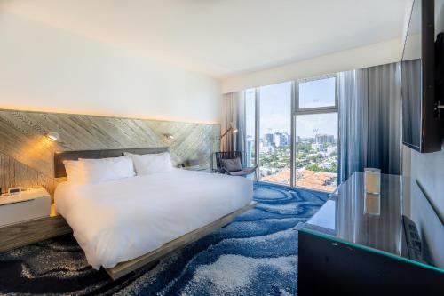フォート・ローダーデールにあるBeachfront-Spacious W Residenceのベッドと大きな窓があるホテルの部屋