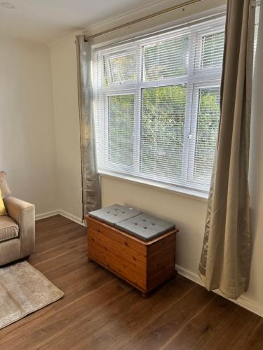 a living room with a table in front of a window at Brand new cosy studio apartment in West Dulwich