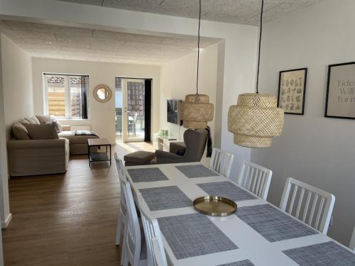 uma sala de estar com uma mesa e um sofá em 3 værelses lejlighed i Give em Give