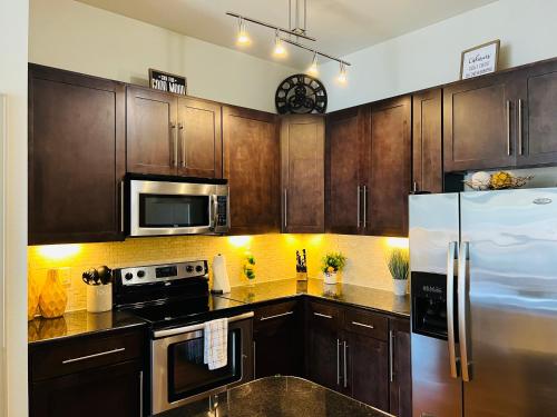 uma cozinha com armários de madeira e um frigorífico de aço inoxidável em One bedroom apt near NRG and Medical Ctr em Houston