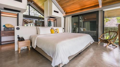 a bedroom with a large bed and large windows at Island Escape Burasari in Phuket Town