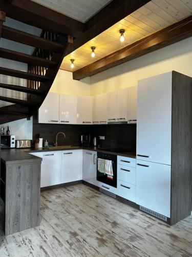 a kitchen with white cabinets and a white refrigerator at Vila Svistovka in Stará Lesná