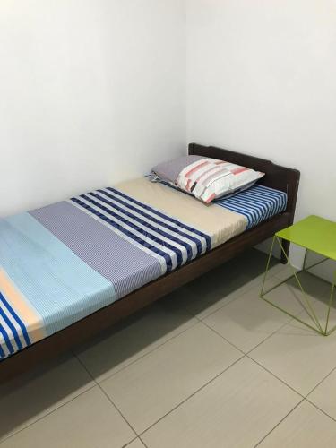a bed in a room with a green table at M1 Budget Comfortable Central in Kuching