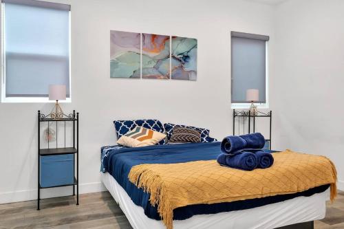 a bedroom with a bed with blue sheets and windows at Hollywood 3BR home near metro in Los Angeles