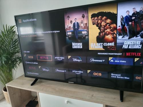 a flat screen tv sitting on top of a wooden stand at KEZA's Apartment - Strasbourg in Strasbourg