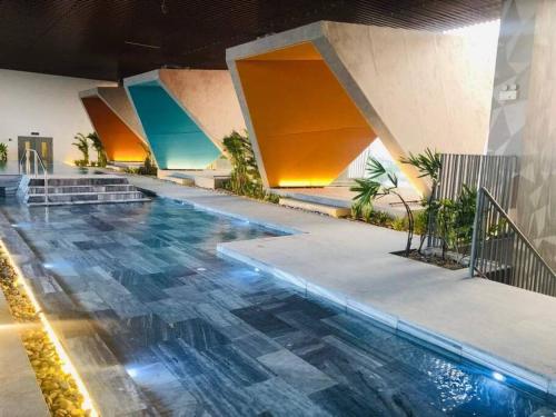 einen Pool in einem Gebäude mit Fliesenboden in der Unterkunft Khu nghĩ dưỡng Emeral Golf View in Thuan An