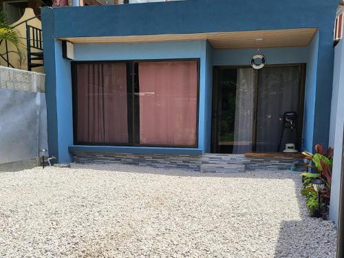 ein blaues Haus mit einem Fenster und einer Tür in der Unterkunft MILA Apartments #1 in Barco Quebrado