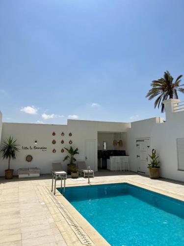 a swimming pool in the middle of a house at Villa Le Domaine Djerba Piscine Chauffée sans vis à vis in Mezraya
