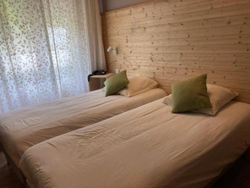 a bedroom with two beds with white sheets and green pillows at Auberge de France in Kruth