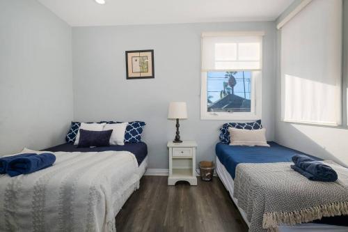洛杉磯的住宿－Comfy 4BR home near Korea Town，一间卧室设有两张床和窗户。