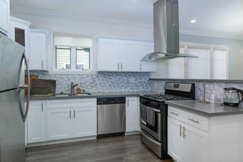 a kitchen with white cabinets and a stove top oven at Comfy 4BR home near Korea Town in Los Angeles