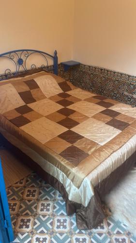 a bedroom with a bed with a checkered floor at BLUE RIAD in Safi