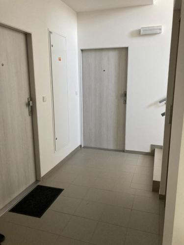 an empty hallway with a door and a tile floor at Apartmán 696 Pod Ještědem in Liberec