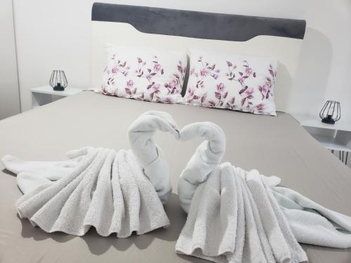 Dos cisnes blancos haciendo un corazón en una cama en Stan na dan Mici, en Brčko