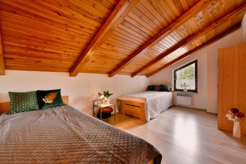 1 dormitorio con cama y techo de madera en Apartmány orlík en Klučenice