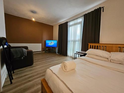 a hotel room with a bed and a flat screen tv at Flat in Camden Town in London