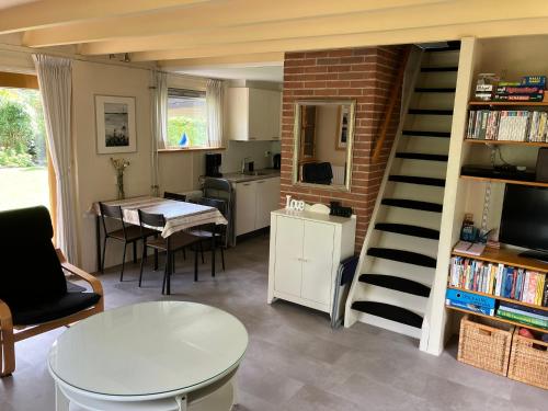 een woonkamer met een wenteltrap en een tafel bij Oasis Giethoorn in Giethoorn
