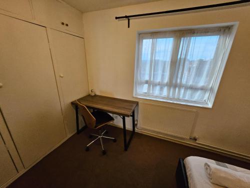 een kleine kamer met een bureau en een raam bij Flat in Camden Town in Londen