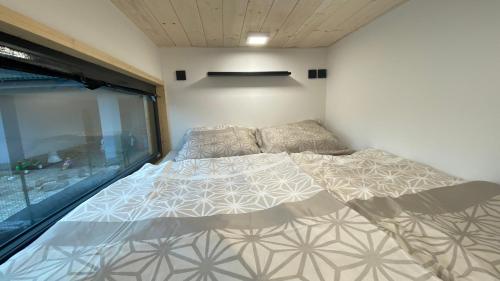 una cama grande en una habitación con ventana en Tiny House, en Pardubice